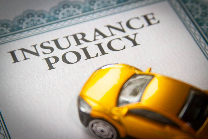 Insurance policy printed on a paper and a toy car